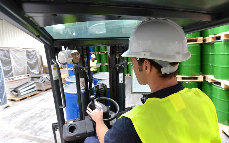 AW Associates fork lift truck operator with hi vis jacket and hard hat.